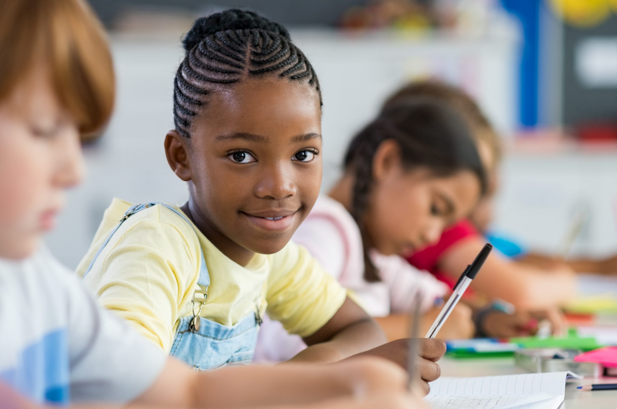 Young black female student smiling in school classroom Young black female student smiling in school classroom
